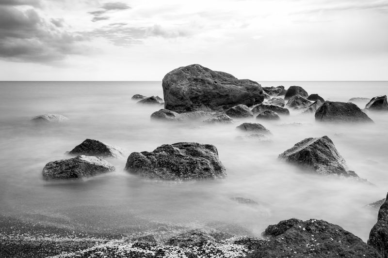 A serene view of Vlychada Beach in Exomitis, Santorini, Greece, with unique rock formations and clear waters.