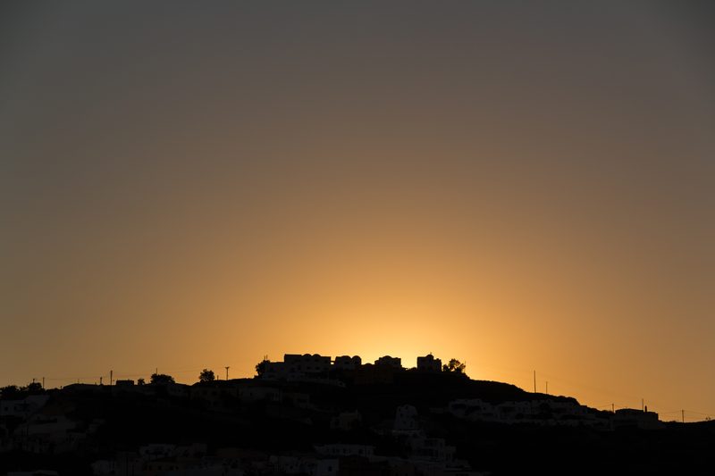 A vibrant sunset over the caldera in Akrotiri, Santorini, Greece.