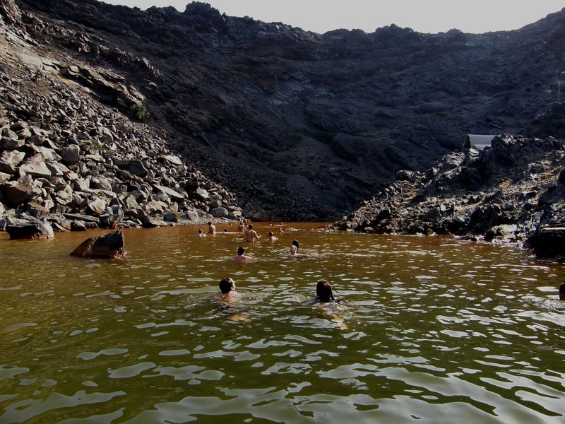 People swimming in the hot springs of Palea Kameni, a volcanic island in Santorini's caldera.